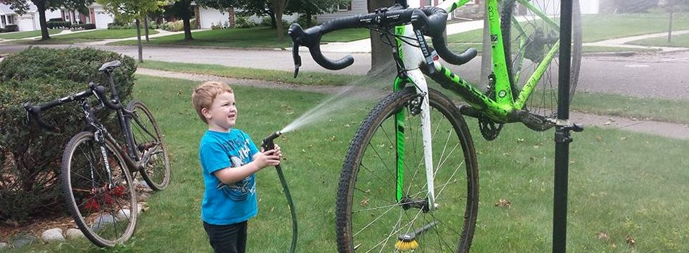 Boy washing bicycle