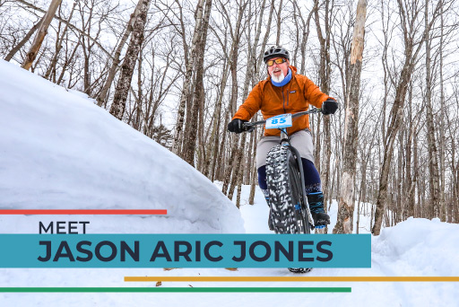 Jason Aric Jones riding mountain bike through woods in snow