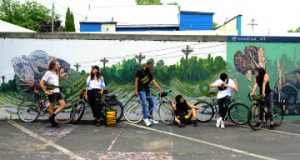 Group of Cyclists standing against painted wall with Wonder Goods gear