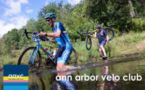 Two cyclists carrying their bicycles through a stream crossing during an off-road cycling race in Michigan