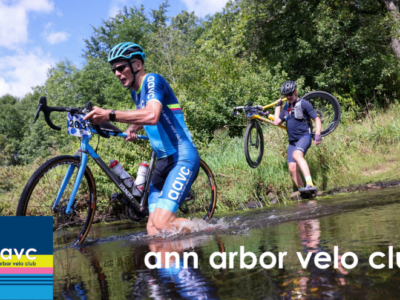 Two cyclists carrying their bicycles through a stream crossing during an off-road cycling race in Michigan